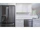 Stainless steel refrigerator, dishwasher and white cabinets in a kitchen with tile backsplash at 248 Pioneer Dr, Mount Gilead, NC 27306