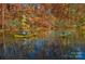 Two people kayaking on a calm lake surrounded by colorful autumn trees, reflecting in the water at 248 Pioneer Dr, Mount Gilead, NC 27306