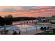 Community pool with lounge chairs and tables overlooking the lake with a sunset sky at 248 Pioneer Dr, Mount Gilead, NC 27306