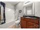 Bathroom featuring vanity with a dark countertop, shower-tub combo, and neutral tones at 25566 Seagull Dr, Lancaster, SC 29720