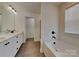Modern bathroom featuring dual sinks, black hardware, and a soaking tub at 2620 Poplar Cove Nw Dr, Concord, NC 28027