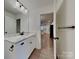 Stylish bathroom with a white dual-sink vanity, marble countertop, and views into the kitchen area at 2620 Poplar Cove Nw Dr, Concord, NC 28027