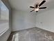 Bright bedroom featuring plush carpeting, a modern ceiling fan, and natural light from a large window at 2620 Poplar Cove Nw Dr, Concord, NC 28027