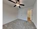 A cozy bedroom with neutral carpet, a ceiling fan, and a glimpse into the en-suite bathroom at 2620 Poplar Cove Nw Dr, Concord, NC 28027