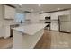 Modern kitchen boasting white cabinets, an island, stainless steel appliances, and wood floors at 2620 Poplar Cove Nw Dr, Concord, NC 28027