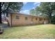 Brick home featuring an American flag, a grassy yard, mature trees, and an air conditioning unit at 2631 Ivey Church Rd, Lincolnton, NC 28092