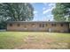 Brick home featuring a grassy yard, mature trees, an air conditioning unit, and a fire pit at 2631 Ivey Church Rd, Lincolnton, NC 28092