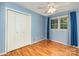 Bright bedroom featuring blue walls, hardwood floors, a ceiling fan, and a closet at 2631 Ivey Church Rd, Lincolnton, NC 28092