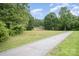 A beautiful, long driveway leads to a charming brick home surrounded by lush trees at 2631 Ivey Church Rd, Lincolnton, NC 28092