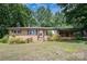 Charming brick home with covered porch and mature trees on a sunny day at 2631 Ivey Church Rd, Lincolnton, NC 28092