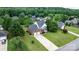 Aerial view showcases a well-manicured lawn and a long driveway to a brick home at 2779 Touchstone Cir, Newton, NC 28658
