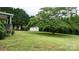 Spacious backyard with mature trees and a storage shed, perfect for outdoor activities and gardening at 2779 Touchstone Cir, Newton, NC 28658