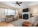 Cozy living room with hardwood floors, plush sofas, fireplace, and a ceiling fan at 2779 Touchstone Cir, Newton, NC 28658
