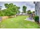 Large, fenced backyard features a well-manicured lawn, patio area and mature trees at 3725 Leela Palace Way, Fort Mill, SC 29708