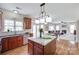 Open kitchen with cherry cabinets, granite countertops, kitchen island, stainless appliances and eat-in table overlooking Gathering room at 3725 Leela Palace Way, Fort Mill, SC 29708