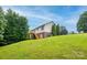 Spacious backyard with lush lawn shows the back of the house, deck, and mature trees at 4059 Caitlins Way, Hickory, NC 28602