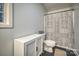 Clean bathroom featuring a toilet, a white storage cabinet and black-and-white shower curtain at 4059 Caitlins Way, Hickory, NC 28602
