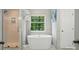 Bright bathroom featuring a modern soaking tub next to a glass enclosed shower and a large window at 415 Glandon Ct, Fort Mill, SC 29708