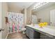 Bright bathroom featuring a gray vanity with a quartz countertop, wood flooring, and a fun shower curtain at 415 Glandon Ct, Fort Mill, SC 29708