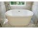 Close-up of a modern white soaking tub in a well-lit bathroom with a large window at 415 Glandon Ct, Fort Mill, SC 29708