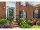 Inviting front porch with brick stairs, black railings, and colorful landscaping around a red brick home at 415 Glandon Ct, Fort Mill, SC 29708