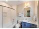 Cozy bathroom featuring modern tub and shower, blue vanity, and neutral walls at 4211 Tangle Dr, Charlotte, NC 28211