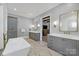 Bright bathroom with tub, double vanity, and gray cabinetry; a relaxing retreat at 4211 Tangle Dr, Charlotte, NC 28211