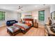 Bright bedroom featuring a ceiling fan, two windows and a plush seating area at 4211 Tangle Dr, Charlotte, NC 28211
