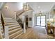 Elegant foyer featuring a staircase, wood floors, and modern lighting fixtures at 4211 Tangle Dr, Charlotte, NC 28211