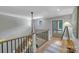 Bright hallway with staircase featuring black iron railing and hardwood floors at 4211 Tangle Dr, Charlotte, NC 28211