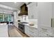 Bright kitchen features white cabinets, a stainless-steel range, and hardwood floors at 4211 Tangle Dr, Charlotte, NC 28211