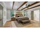 Relaxing main bedroom boasts beamed ceilings, plush bedding, and windows at 4211 Tangle Dr, Charlotte, NC 28211