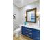 A stylish powder room featuring blue vanity and geometric wallpaper at 4211 Tangle Dr, Charlotte, NC 28211
