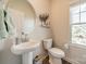 Cozy half-bath features pedestal sink, round mirror, and an abundance of natural light at 4439 Millennium Ave, Charlotte, NC 28217