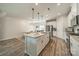 Bright kitchen boasts an island, stainless appliances, and a view to the dining area at 4439 Millennium Ave, Charlotte, NC 28217
