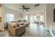 Spacious living room featuring modern ceiling fan, wood floors, and natural light from the large windows at 4439 Millennium Ave, Charlotte, NC 28217
