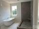 Luxurious bathroom featuring a modern soaking tub and a separate tiled shower with a built-in bench at 4622 Serenity Woods Ct, Charlotte, NC 28216