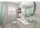 Bright bathroom features a modern vanity, updated fixtures, and decorative shelving near the window at 505 Melody Ln, Shelby, NC 28152