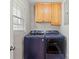 A functional laundry room features a modern washer and dryer and upper cabinets for storage at 505 Melody Ln, Shelby, NC 28152