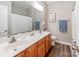Well-lit bathroom featuring a double vanity, wood-look floors, and fresh towels at 537 Montgrove Nw Pl, Concord, NC 28027