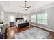 Tranquil main bedroom showcasing a ceiling fan, large windows, and hardwood floors at 537 Montgrove Nw Pl, Concord, NC 28027