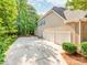 An exterior view of the home showcasing a two-car garage, lengthy driveway, and well-maintained landscaping at 537 Montgrove Nw Pl, Concord, NC 28027