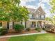Charming brick home boasts a covered front porch, lush lawn, and mature trees, creating a warm, inviting curb appeal at 537 Montgrove Nw Pl, Concord, NC 28027