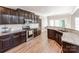 Well-lit kitchen featuring stainless steel appliances, dark cabinets, and granite countertops at 537 Montgrove Nw Pl, Concord, NC 28027
