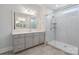 Modern bathroom featuring a glass shower with a built-in seat, dual sinks, and updated fixtures at 5590 Elk Knob Ct, Denver, NC 28037