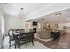 Open-concept dining area with modern chandelier, table, and view to living room at 5590 Elk Knob Ct, Denver, NC 28037