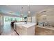 Open-concept kitchen with a large island, farm sink, and seamless flow to dining and living areas at 5590 Elk Knob Ct, Denver, NC 28037