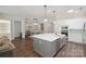 Spacious kitchen with white cabinets, center island, stainless appliances, and wood flooring throughout at 5590 Elk Knob Ct, Denver, NC 28037