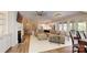 Spacious living room featuring hardwood floors, a fireplace, and an open layout to the kitchen and dining area at 5590 Elk Knob Ct, Denver, NC 28037