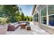 A beautiful stone patio features comfortable wicker seating near the home's large windows at 5590 Elk Knob Ct, Denver, NC 28037